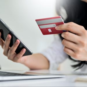 Young woman holding credit card and smartphone with laptop, Credit card payment.