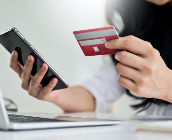 Young woman holding credit card and smartphone with laptop, Credit card payment.